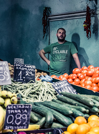 A Greek market stall holder looks over his products  by Preston based street photographer Alf Myers