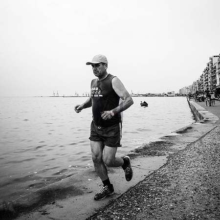 A runner running alongside the sea in Thessaloniki, Greece. Image by Preston based street photographer Alf Myers