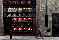 An images of a man walking by the Tea House shop in London by Preston based street photographer Alf Myers