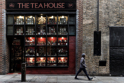 An images of a man walking by the Tea House shop in London by Preston based street photographer Alf Myers
